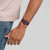 Montre Swatch Thru the Crown Glass SO28R115, cadran rouge, portée au poignet